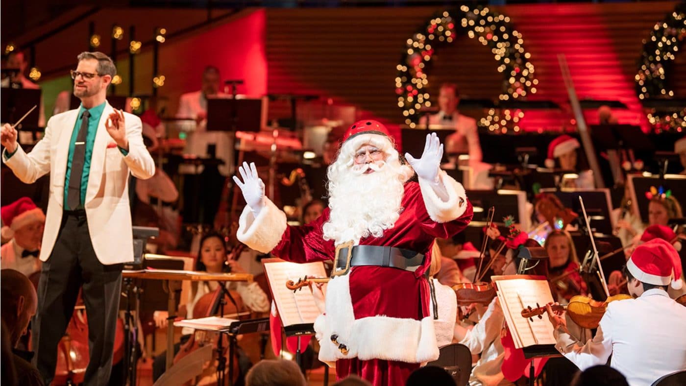 Photo of Jason Seber, Santa Claus and the Kansas CIty Symphony on stage in Helzberg Hall at Christmas Festival