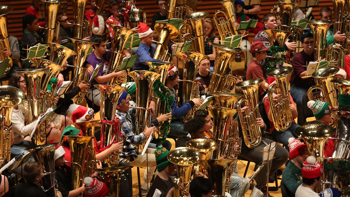 Photo of multiple tuba players on stage in Helzberg Hall at TubaChristmas
