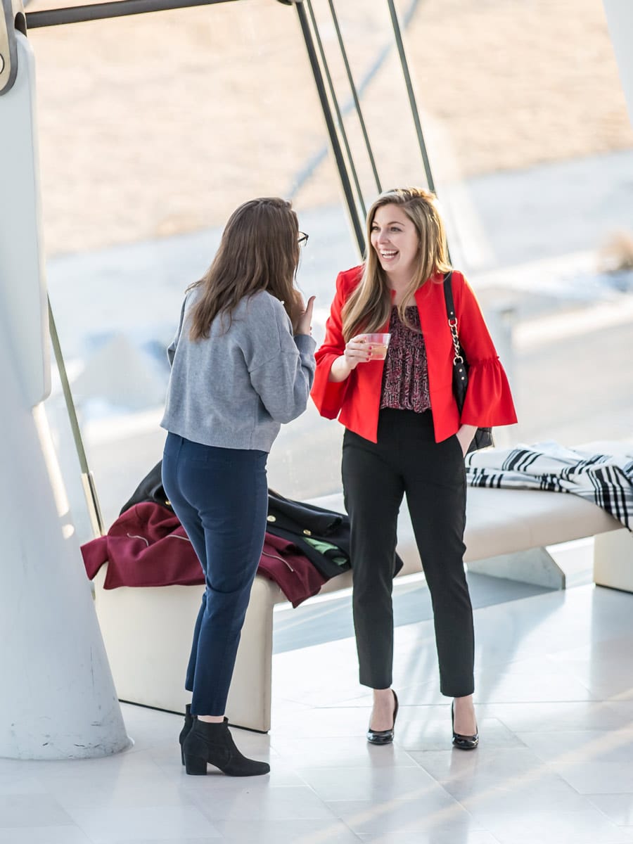 Photo of two women in the lobby of the Kauffman Center for Performing Arts talking and laughing before a Symphony event.